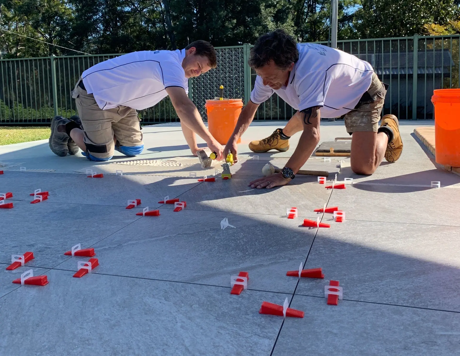 Lay My Tiles team laying large-format outdoor tiles with levelling clips on the Gold Coast