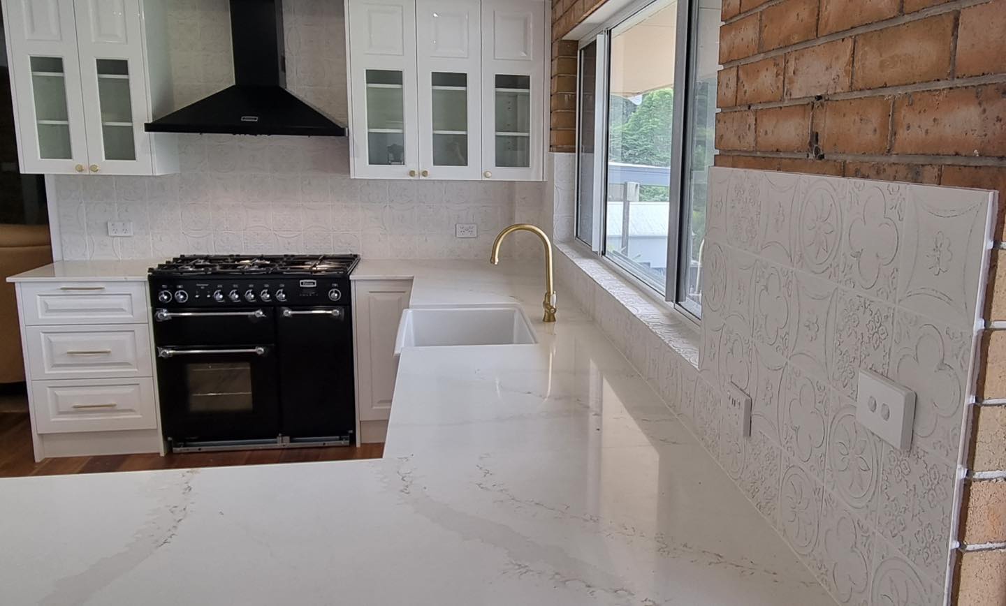 Textured splashback with brick-look tile and range hood