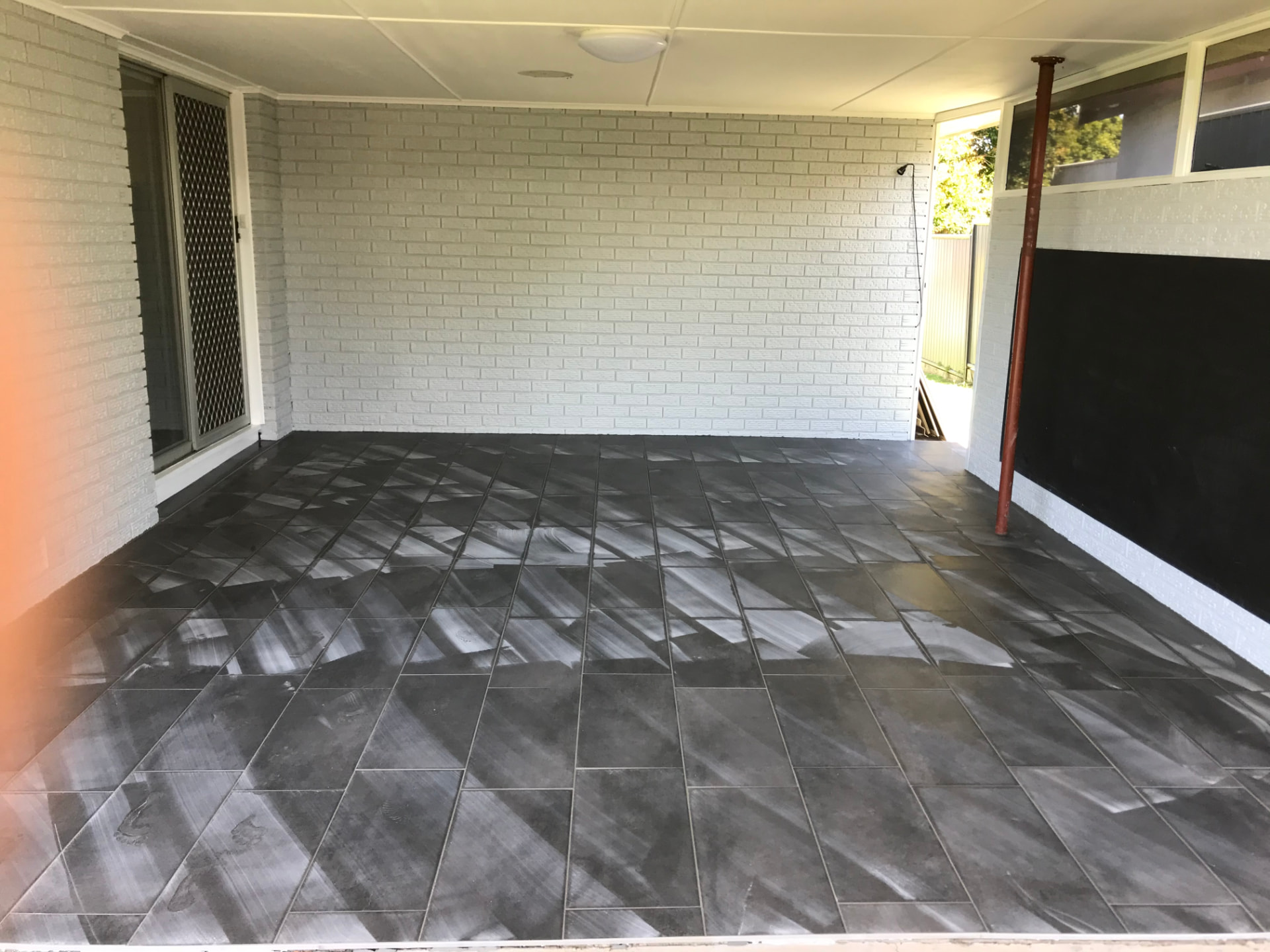 Undercover patio with dark grey outdoor tiles laid on the Gold Coast